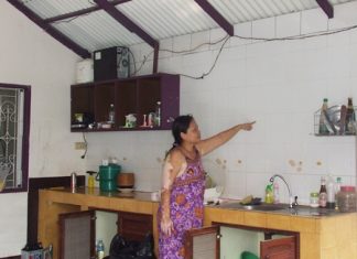 Pa Thongmuan points out how high she said the flood waters reached inside her home.